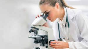 A pharmacy worker at a microscope